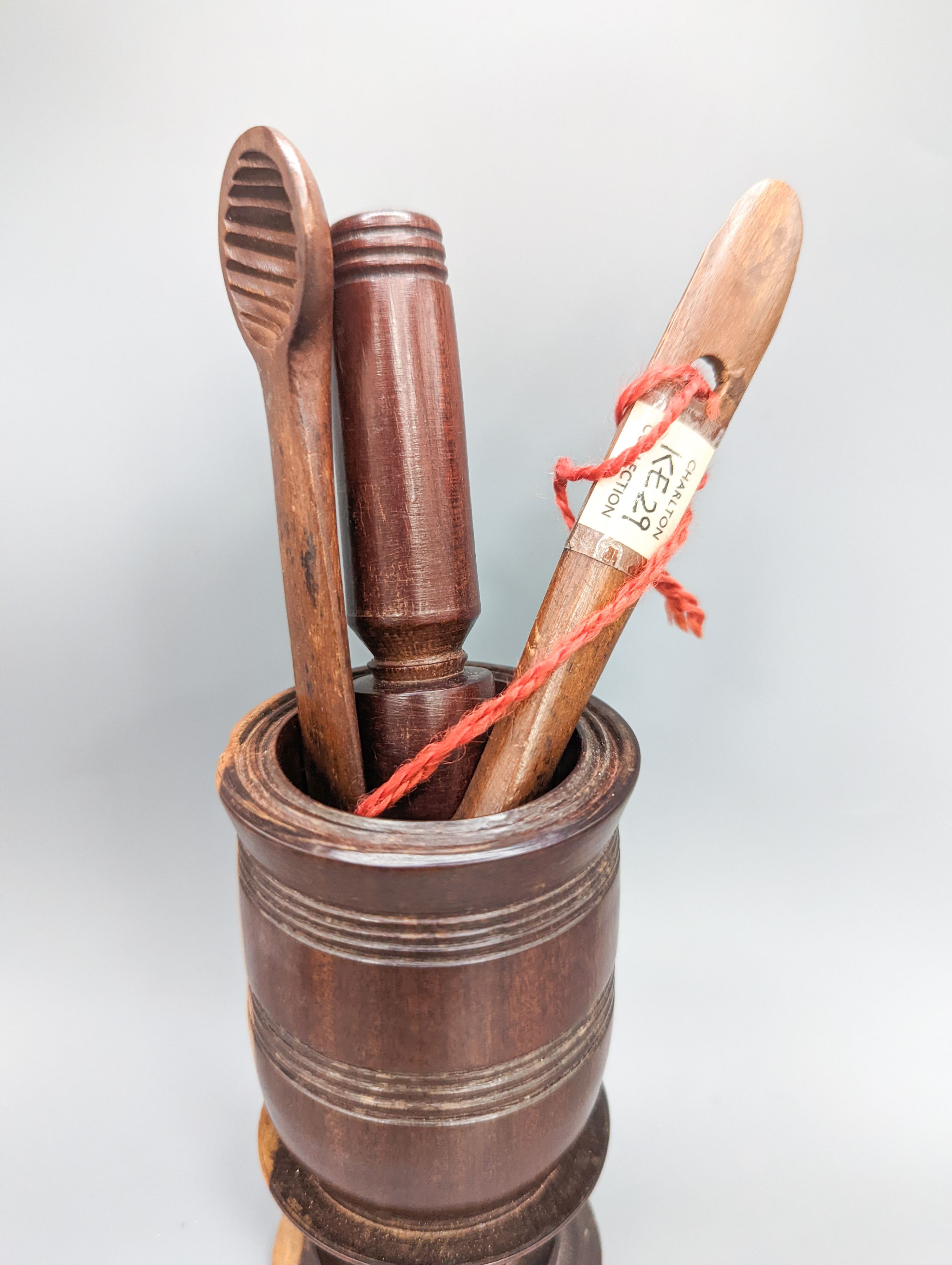 A 19th century lignum vitae pestle and mortar, 10.5cm, a pair of treen butter spoons and an agate mounted brass pillbox